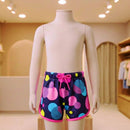 Manequim infantil exibindo short de banho estampado com acabamento em viés