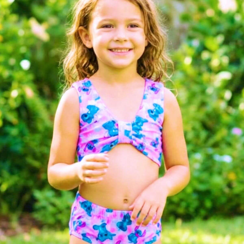 Biquíni infantil rosa com estampa do personagem Stitch azul espalhada por toda a peça.