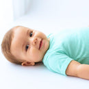 menino sorrindo com o body infantil na cor verde