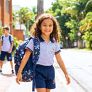 Criança estudante ao ar livre com mochila nas costas, estudante caminhando no campus educacional, adolescente sorrindo em área externa
