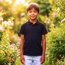 Menino sorrindo no jardim vestindo camisa polo infantil vermelha e bermuda jeans clara