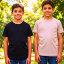 Dois meninos sorrindo lado a lado em um parque: um veste camiseta preta lisa e o outro camiseta bege.