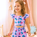 "Conjunto infantil lilás com estampa de desenhos divertidos azuis e rosas.