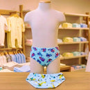 Organização de loja infantil mostrando variedade de cuecas slip coloridas e estampadas.