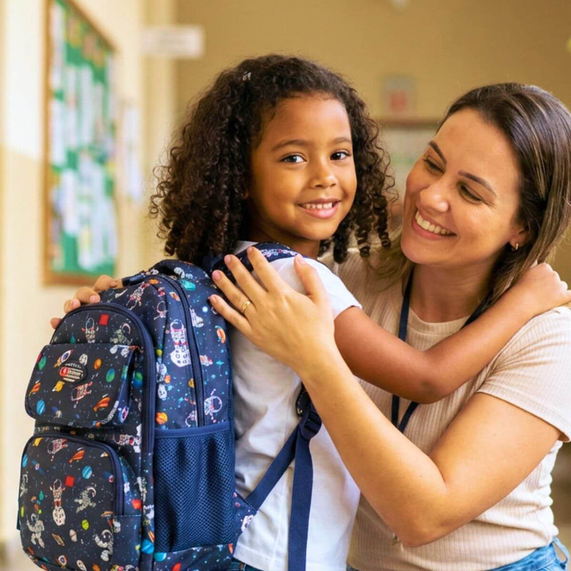 Estudando abraçando a professora dentro da escola, com a mochila do astronauta