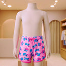 Manequim infantil exibindo short de banho estampado com acabamento em viés