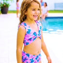 menina usando biquini infantil na beira de uma piscina com a familia