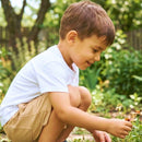 Menino agachado com bermuda na cor bege 