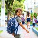 menino, entrando na escola para estudar. Ele está com a mochila azul marinho
