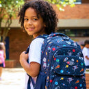 menino, cabelo cacheado, usando mochila dentro da escola