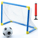 Menino de camiseta vermelha chutando a bola para o gol azul enquanto brinca com amigas no parque