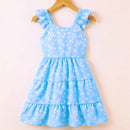 Vestido infantil azul claro com estampa de flores brancas pequenas pendurado em cabide de madeira