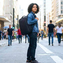 adolescente sorrindo com mochila saindo da faculdade