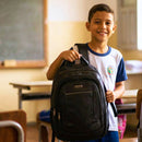 mochila infantil preta para escola com criança em sala de aula
