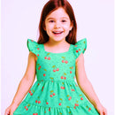 menina com cabelo ruivo usando vestido infantil na cor verde com estampa de cereja